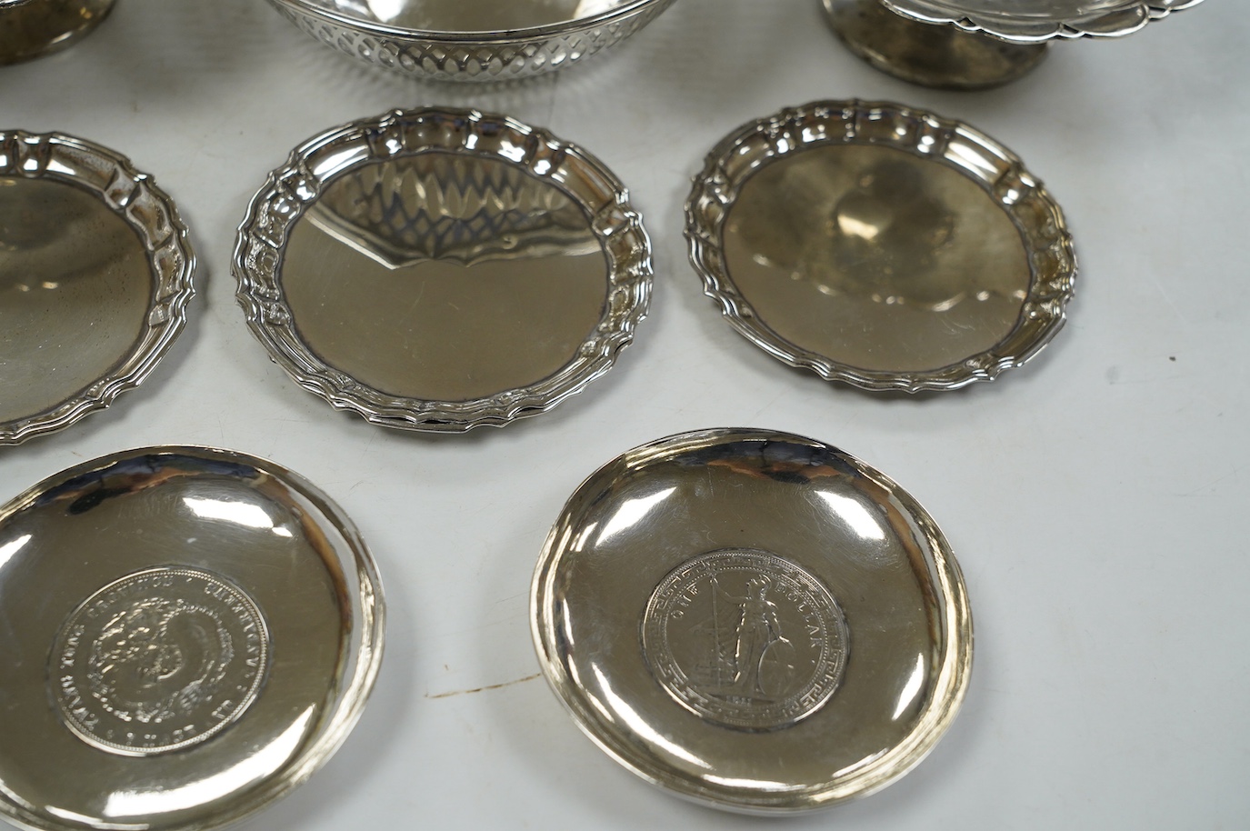 A pair of George V silver pedestal bonbon dishes, Birmingham, 1916, diameter 12.7cm, a set of four similar silver glass coasters, a silver bonbon bowl and a pair of Chinese white metal dishes with inset coin bases by Wan